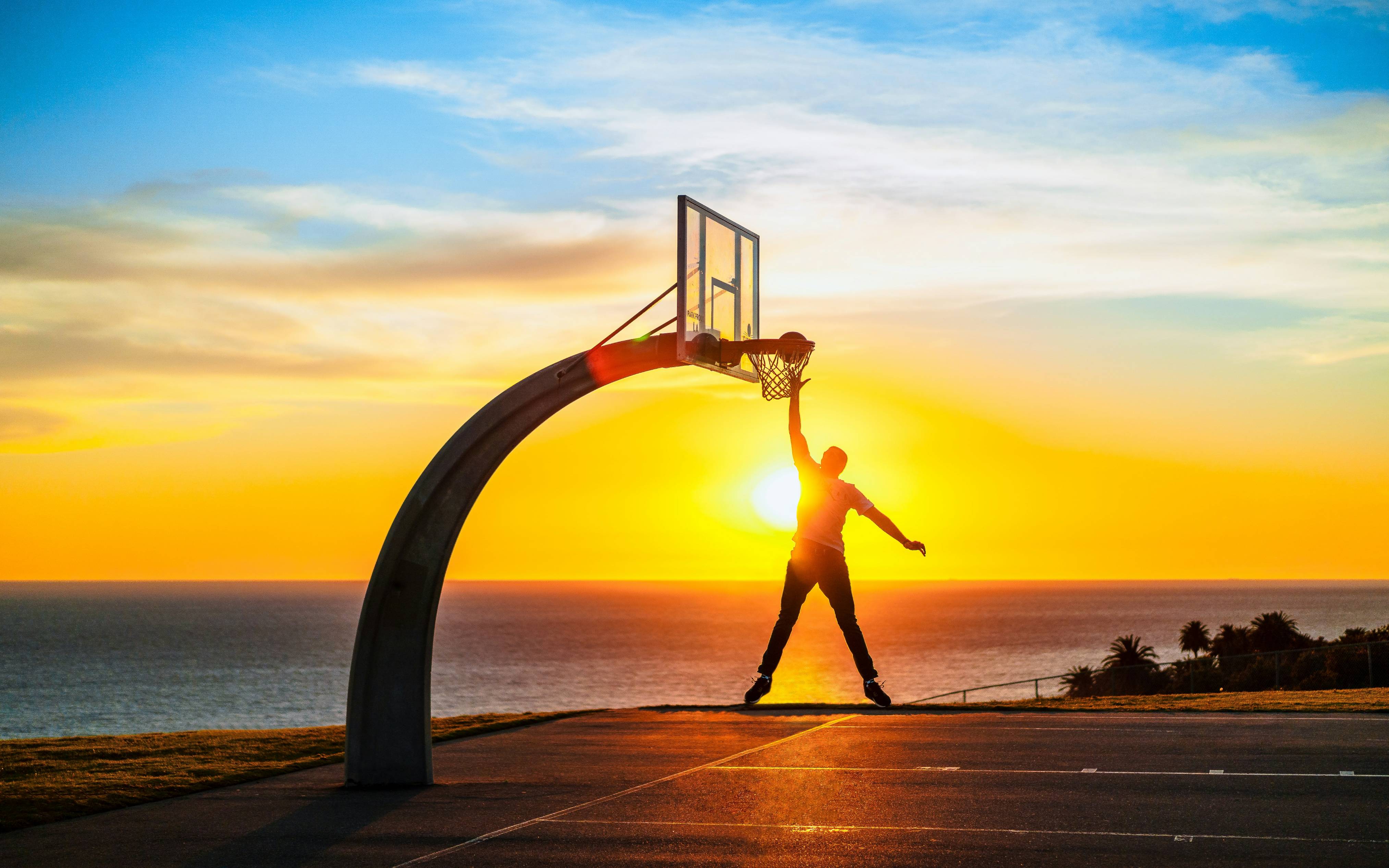a person running on a road with a basketball hoop in the background