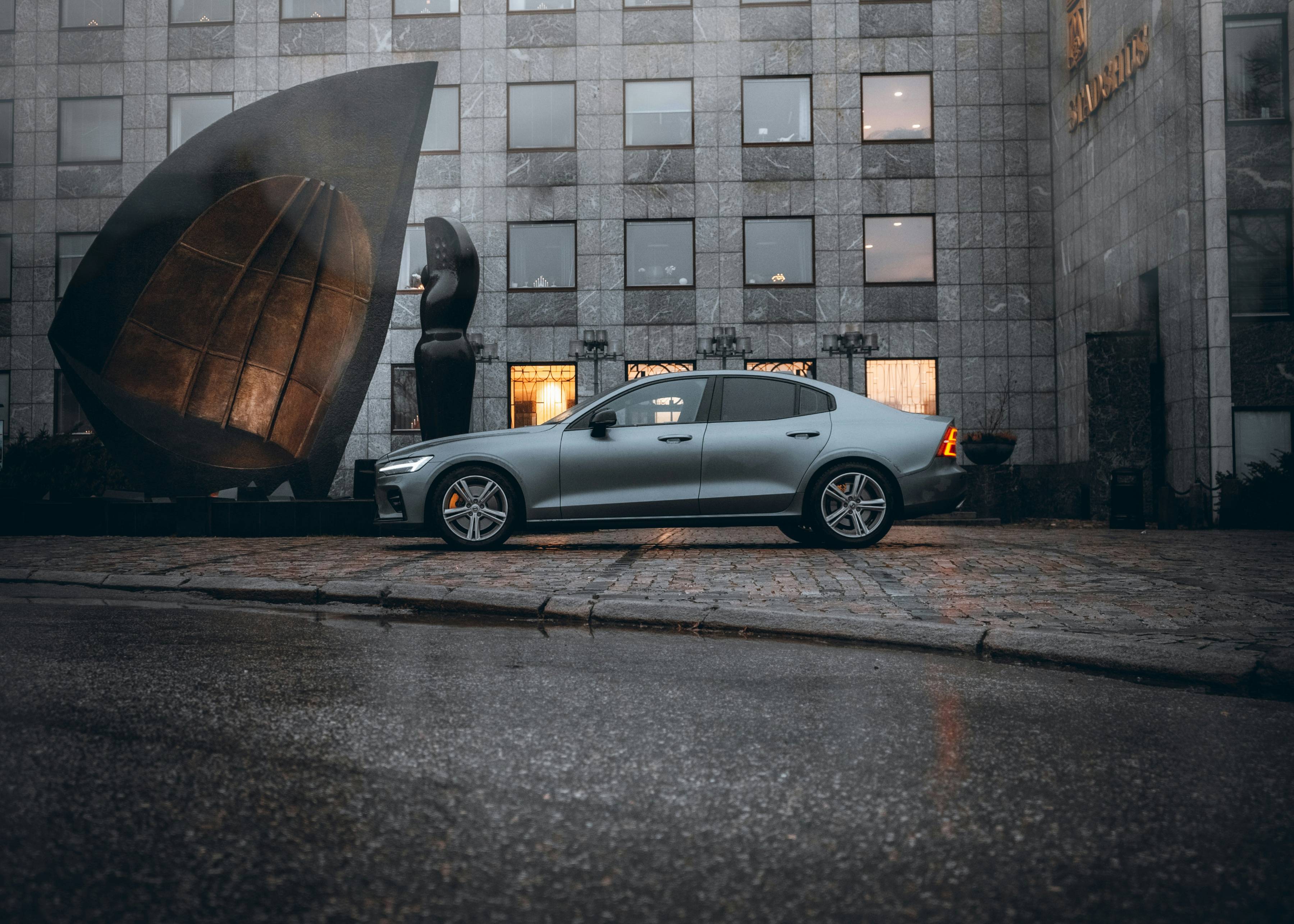 silver sedan parked beside building